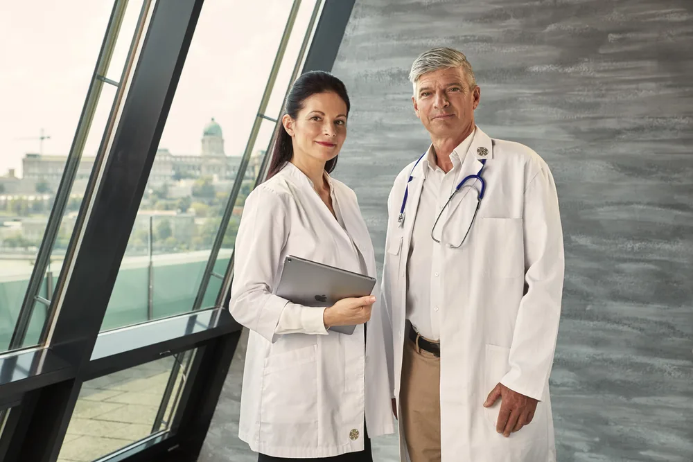 Two physicians at Dr. Rose Private Hospital, Buda Castle behind them