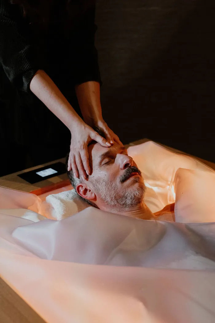 A guest on the dry float bed at Melea, a therapist at his side